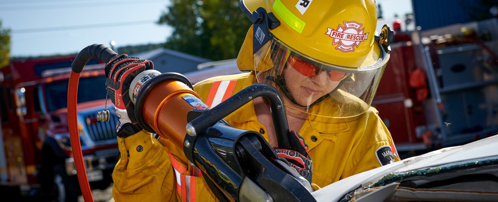 Firefighter using auto extraction device on a vehicle