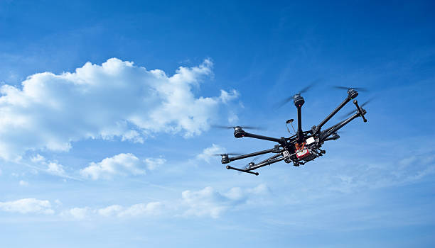 Drone flying in sky with clouds